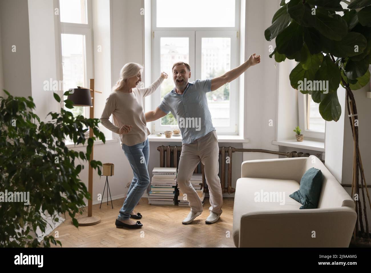 Aufgeregt glückliches Seniorenpaar tanzt zusammen zu Musik Stockfoto