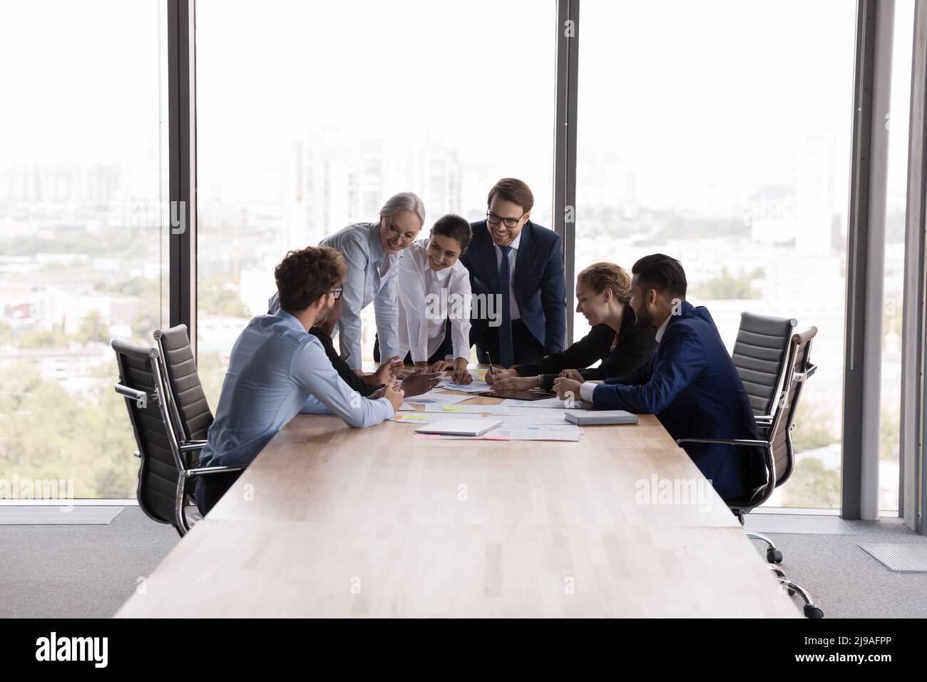 Ältere und junge Teamkollegen versammelten sich im Sitzungssaal bei der Unternehmensbesprechung Stockfoto