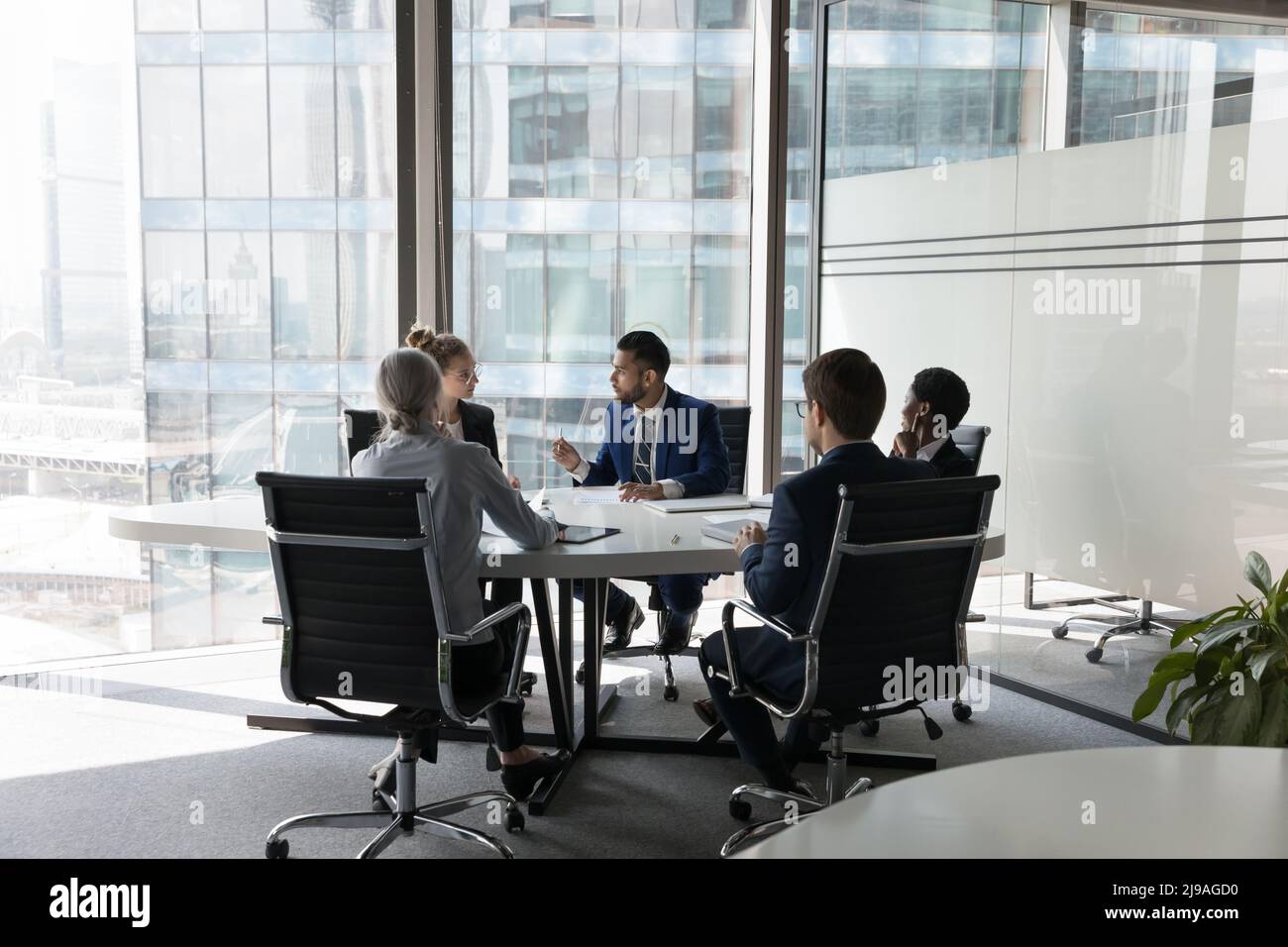Fünf multiethnische Geschäftsleute verhandeln in einem modernen Sitzungssaal Stockfoto