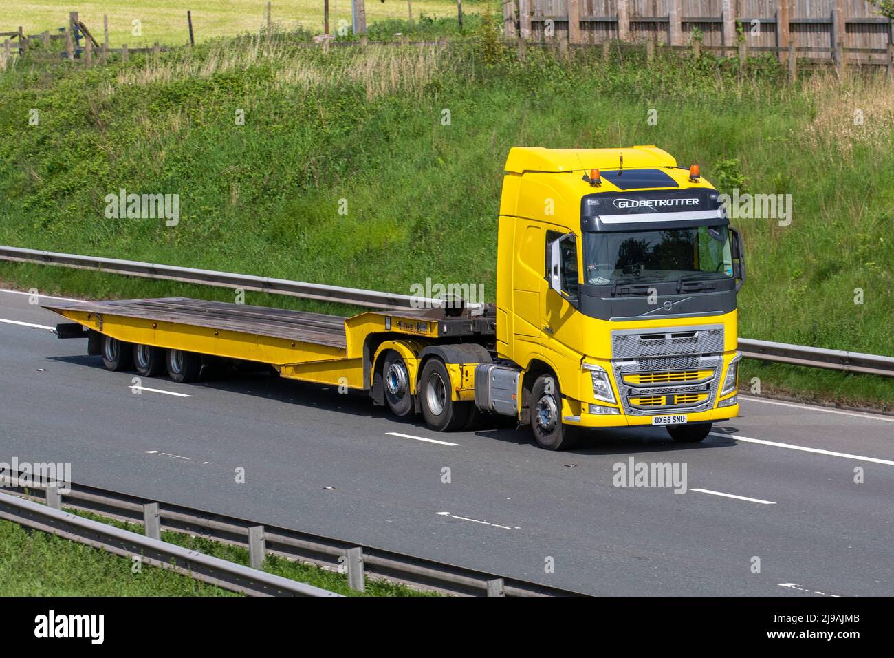 2015 gelber Volvo FH500 6X2T PA XHSL 12777 cc Globetrotter Traktoreinheit mit Anhänger; Fahren auf der Autobahn M6, Manchester, Großbritannien Stockfoto