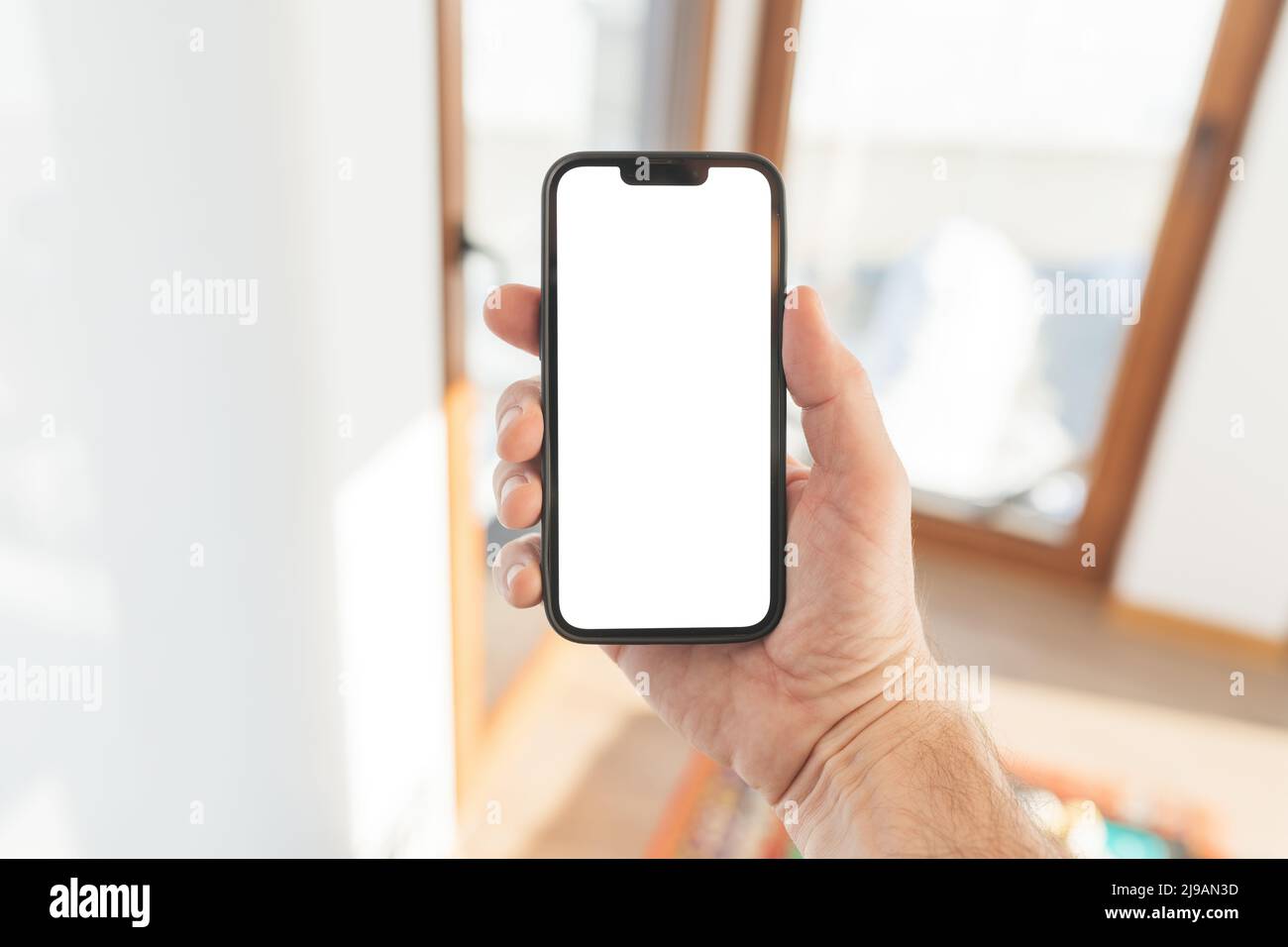 Smartphone-Mockup, Internet der Dinge und Smart-Home-Konzept, Mann mit Mobiltelefon. Nahaufnahme der Handhaltevorrichtung mit leerem Bildschirm im Home Interi Stockfoto