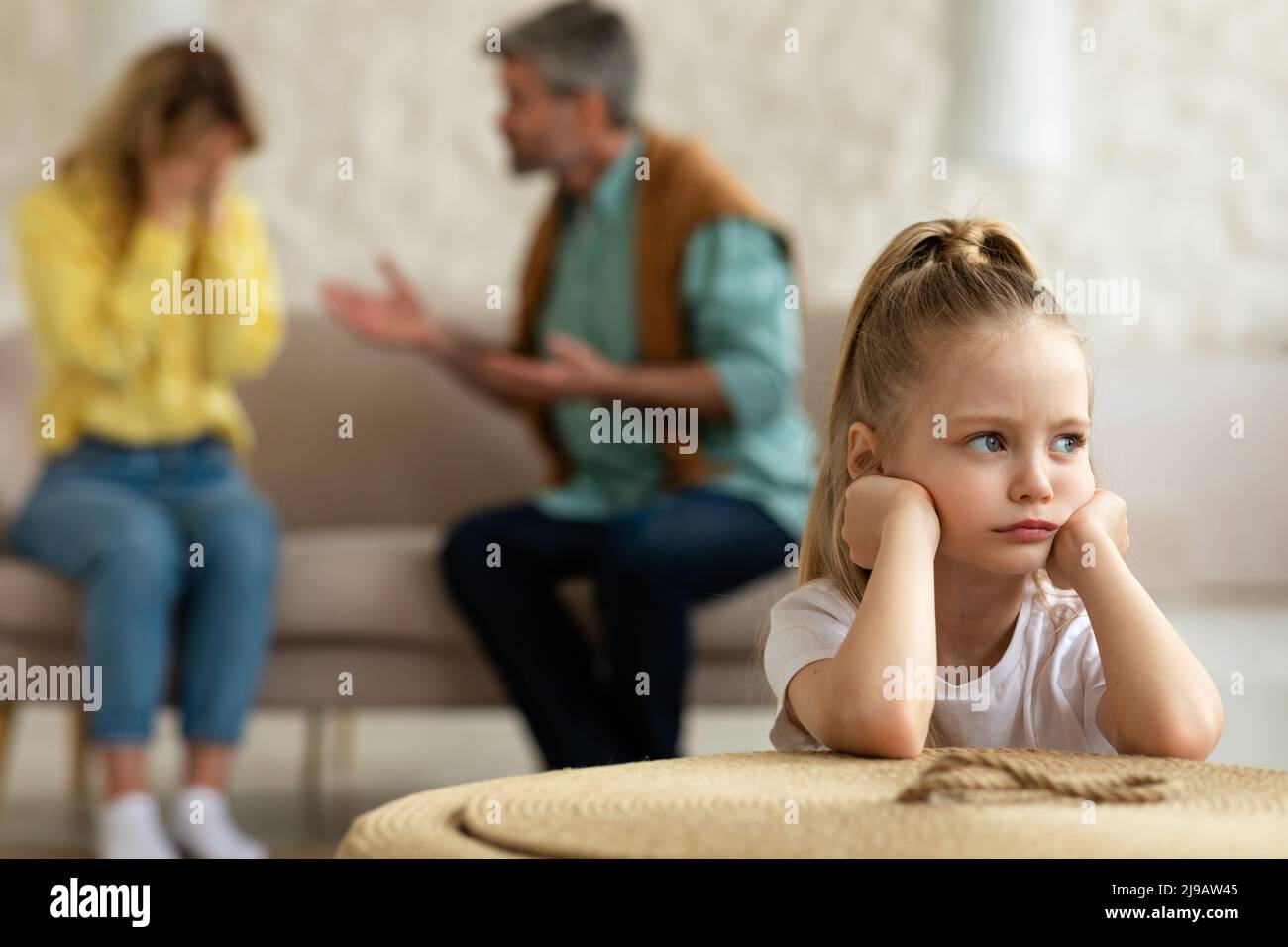 Eltern Haben Streit, Während Unglückliche Kleine Tochter Zu Hause Sitzt Stockfoto