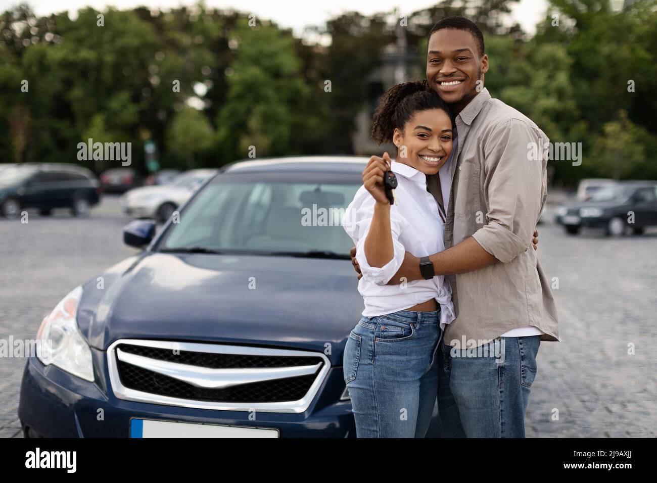 Happy African Couple Zeigt Neuen Autoschlüssel Umarmt Stehen Im Freien Stockfoto