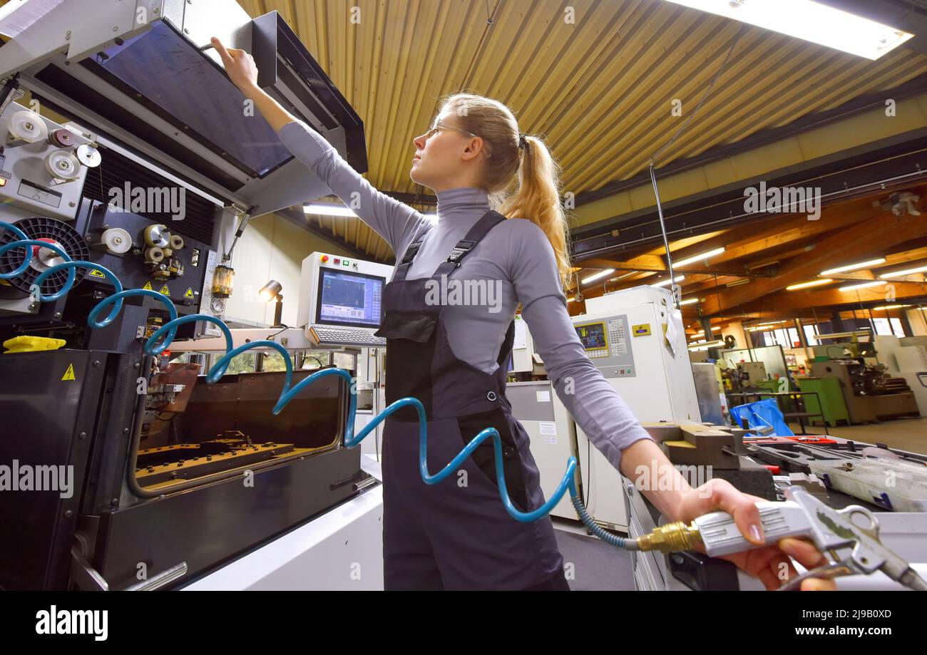 Eine weibliche Auszubildende erhält von ihrer Ausbilderin technischen Unterricht. Beide Frauen arbeiten als computergesteuerte numerische Steuerungstechniker. Stockfoto