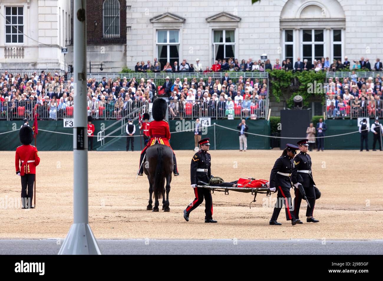 Ein Mitglied der Irischen Garde, das heute während der Überprüfung des Generalmajors über das Trooping the Color bei der Horse Guards Parade unter der hohen Temperatur ohnmächtig wird Stockfoto