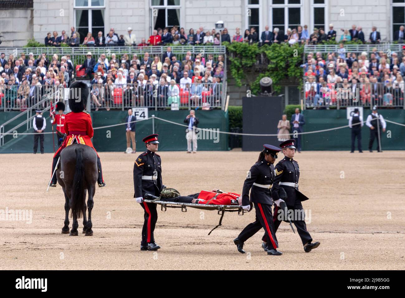 Ein Mitglied der Irischen Garde, das heute während der Überprüfung des Generalmajors über das Trooping the Color bei der Horse Guards Parade unter der hohen Temperatur ohnmächtig wird Stockfoto