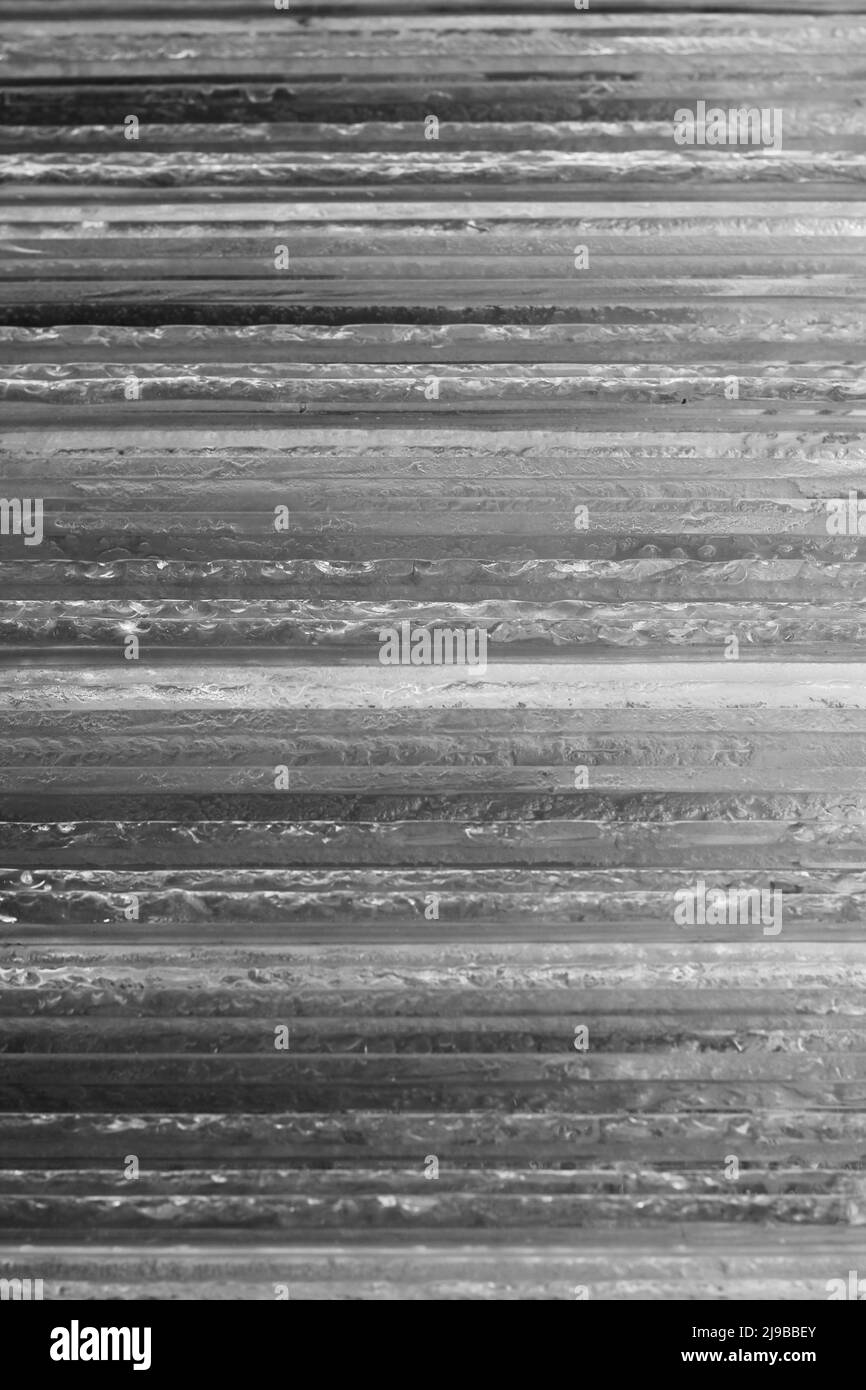Glasschichten, die als Stapel horizontaler Platten in Schwarz und Weiß aufeinander gelegt sind. Stockfoto