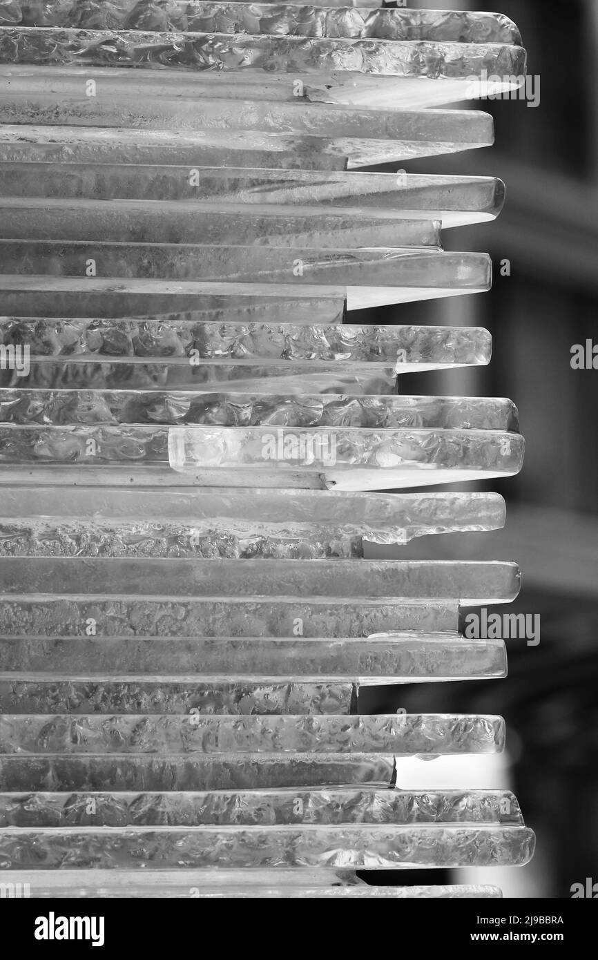 Glasschichten, die als Stapel horizontaler Platten in Schwarz und Weiß aufeinander gelegt sind. Stockfoto
