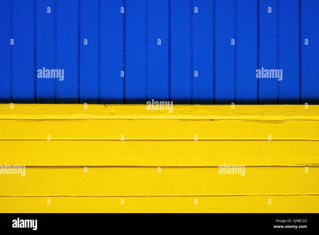 Wie die ukrainische Flagge. Holzvertäfelung des Hauses. Leuchtend blaue und gelbe Farben Stockfoto