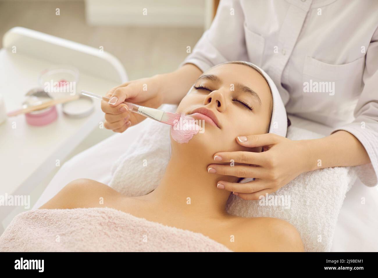 Kosmetikerin machen Gesichtsmaske zu Frau Client Stockfoto