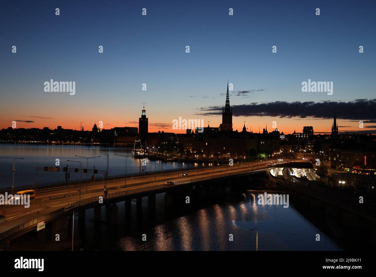 Blick über die Stadt Stockholm, die Hauptstadt Schwedens, von Slussen aus während der Goldenen Stunde über das Wasser. Farben und Wolken am Himmel Stockfoto