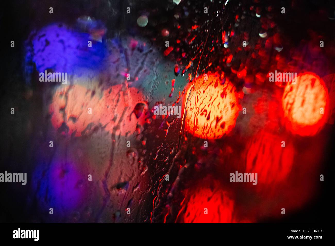 Bokeh Lichter der Autos hinter dem Fenster - Verkehr bei Nacht Konzept Hintergrund Stockfoto