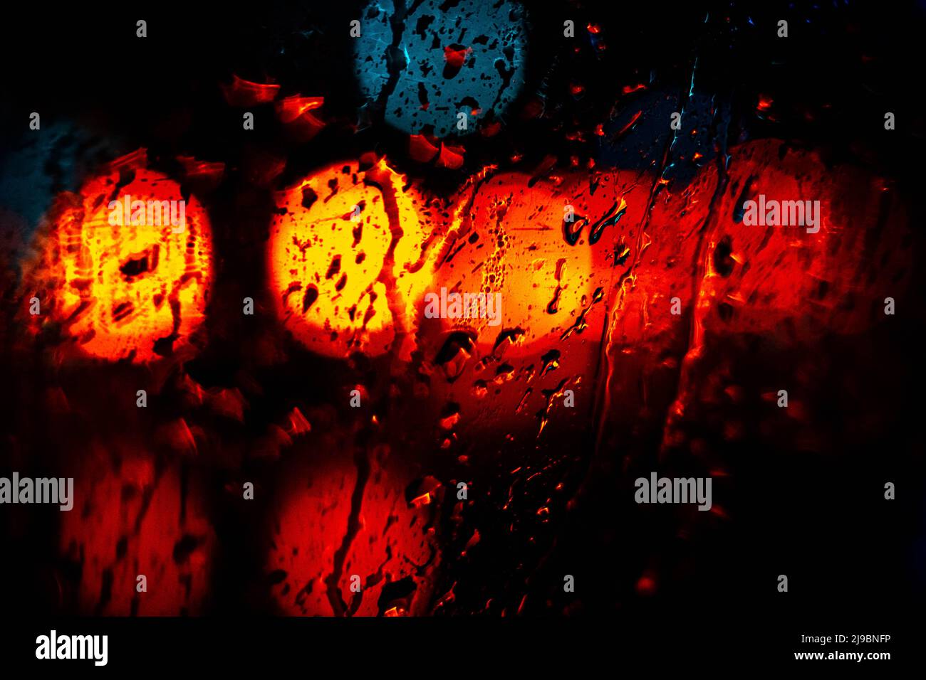 Bokeh Lichter des Autoverkehrs in regnerischer Nacht, abstrakter Hintergrund Stockfoto