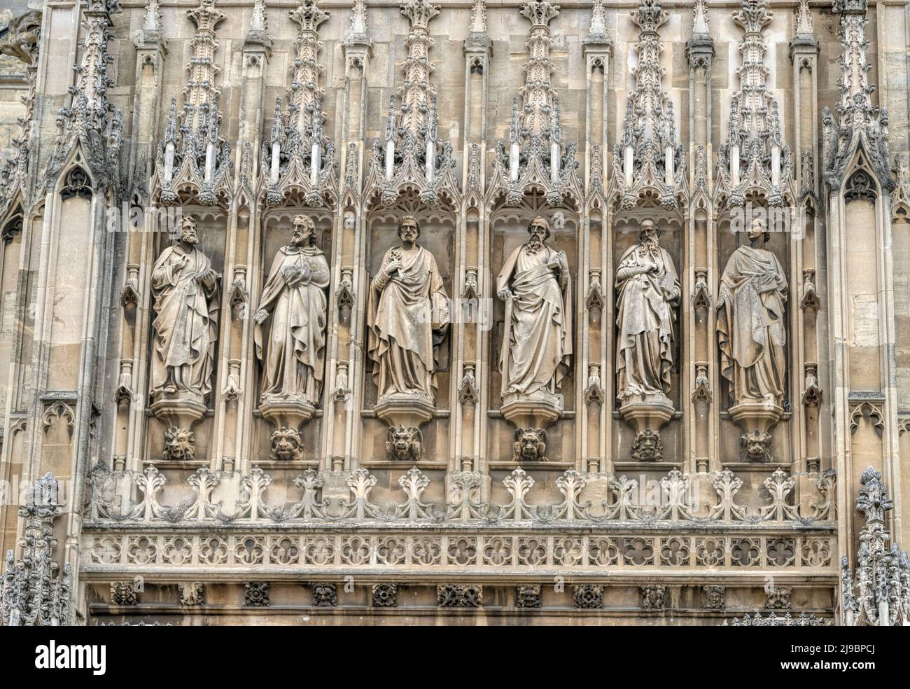 Religiöse Statuen und Grotesken über dem Haupteingang Veranda der Südfassade von Gloucester Cathedral, Gloucestershire, England, Vereinigtes Königreich. Stockfoto