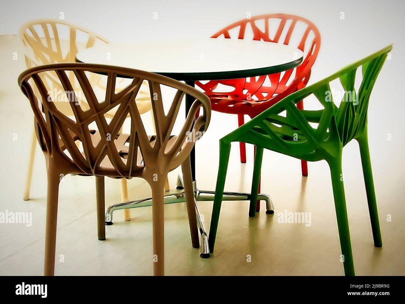 Moderne, mehrfarbige Plastikstühle und -Tische. Modische Innenausstattung Stockfoto