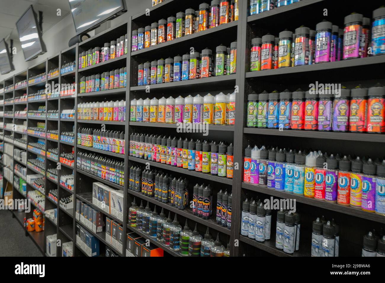 Viele verschiedene Geschmacksrichtungen von E-Liquid-Vapes in einem Vape-Shop. Stockfoto