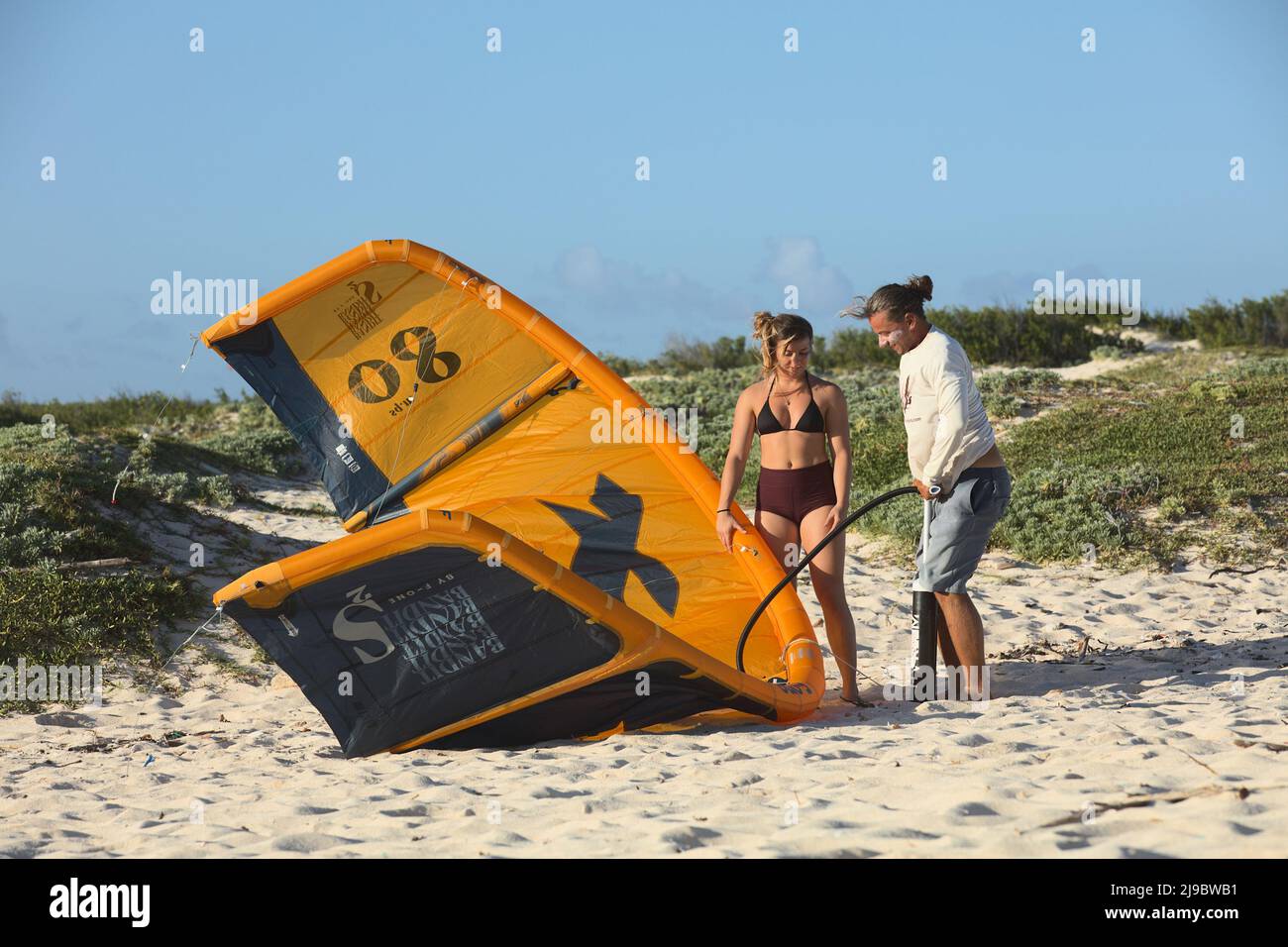 BOCA GRANDI, ARUBA - 17. DEZEMBER 2020: Junger Mann, der am Boca Grandi Strand auf der karibischen Insel Aruba einen F-One Bandit zum Surfen aufbläst Stockfoto