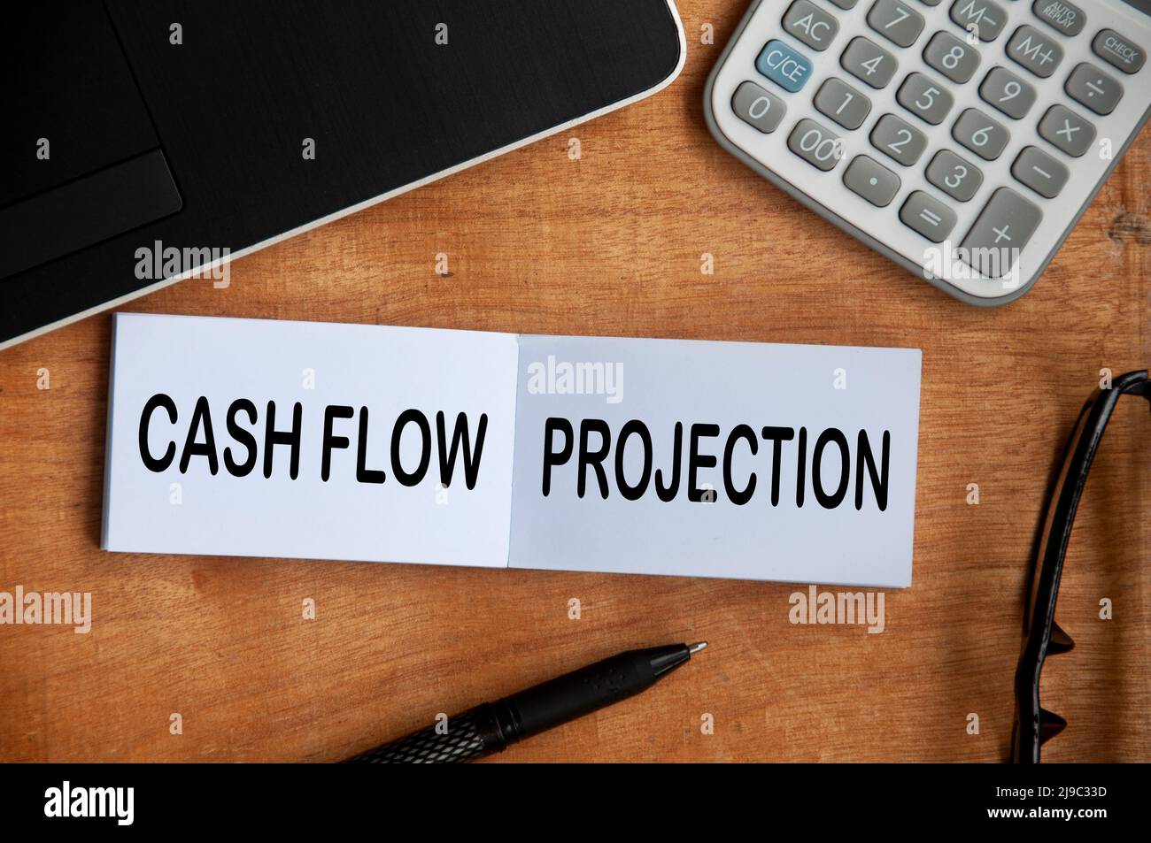 Cashflow-Projektion Text auf Notizblock mit Rechner, Stift und Laptop-Hintergrund. Geschäftskonzept Stockfoto