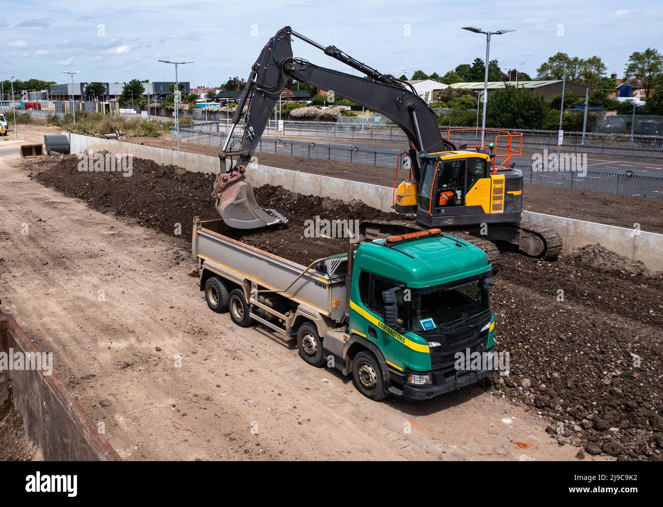 Eine schwere Baggermaschine, die einen Kipper mit Beute von einem Gleis der Eisenbahntechnik beladen hat Stockfoto