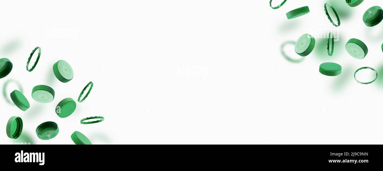 Grüne Flaschenverschlüsse zum Recycling auf weißem Hintergrund. Kunststoffkappen fliegen, schweben. Das Konzept der Sicherheit vor Umweltschäden. Stockfoto