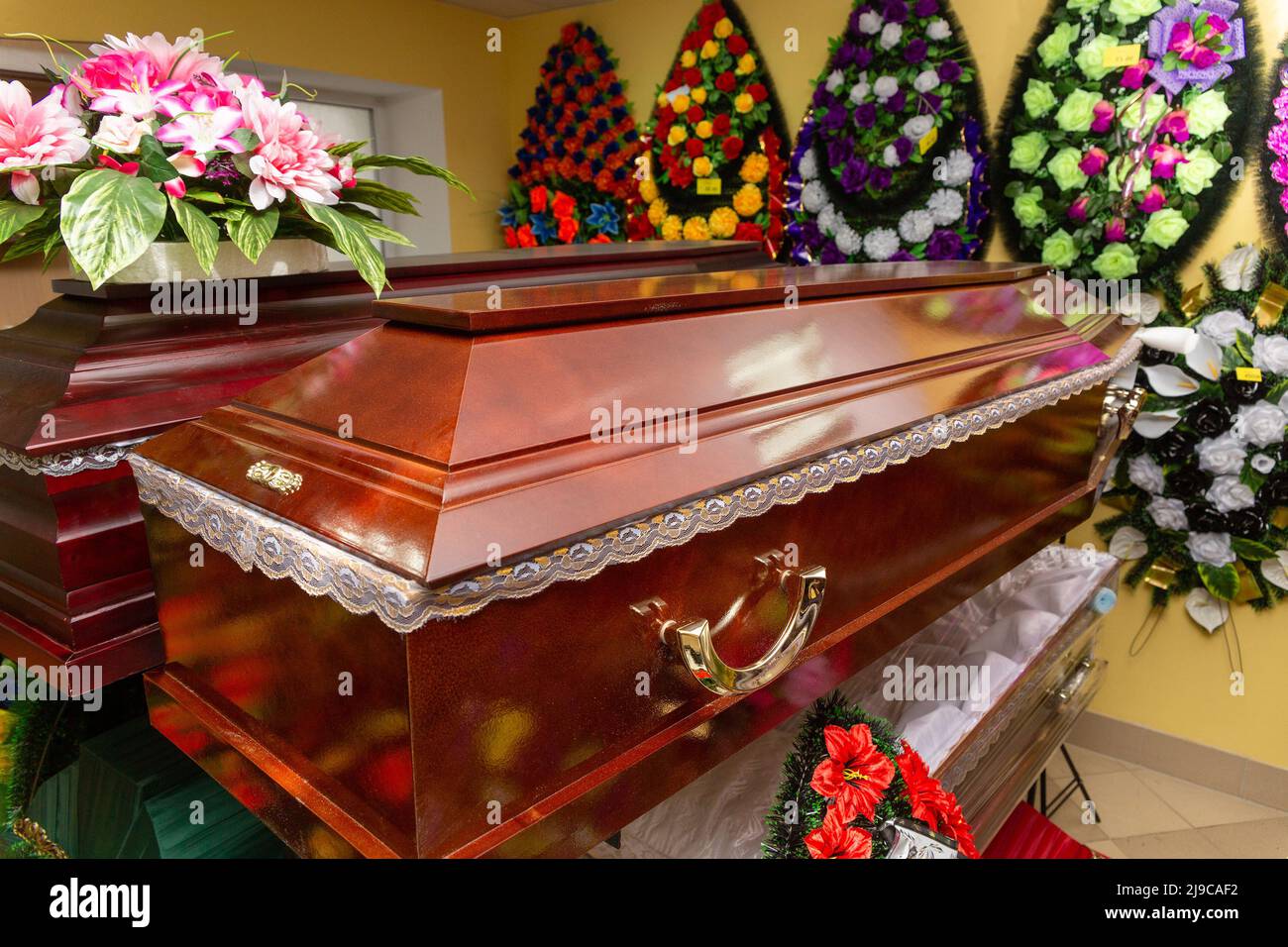 Innenraum des Raumes mit Bestattungszubehör. Geschäft mit Särgen, Beerdigungskränzen und Blumen. Stockfoto