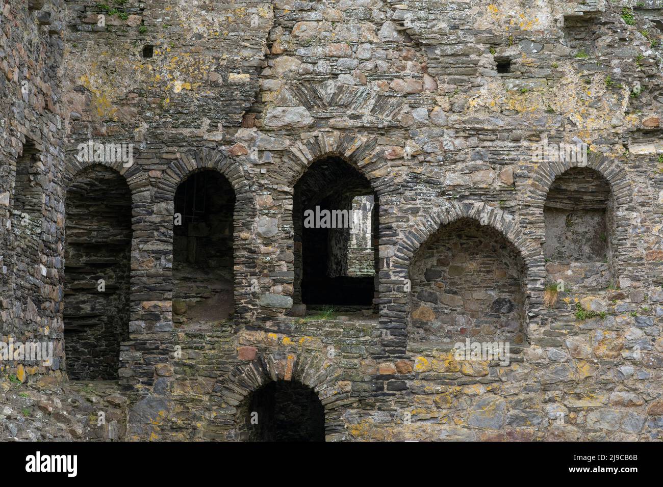Gewölbte Öffnungen und Eingänge in Kidwelly Castle, einem ruinierten normannischen Schloss in Carmarthenshire, Wales, Großbritannien Stockfoto