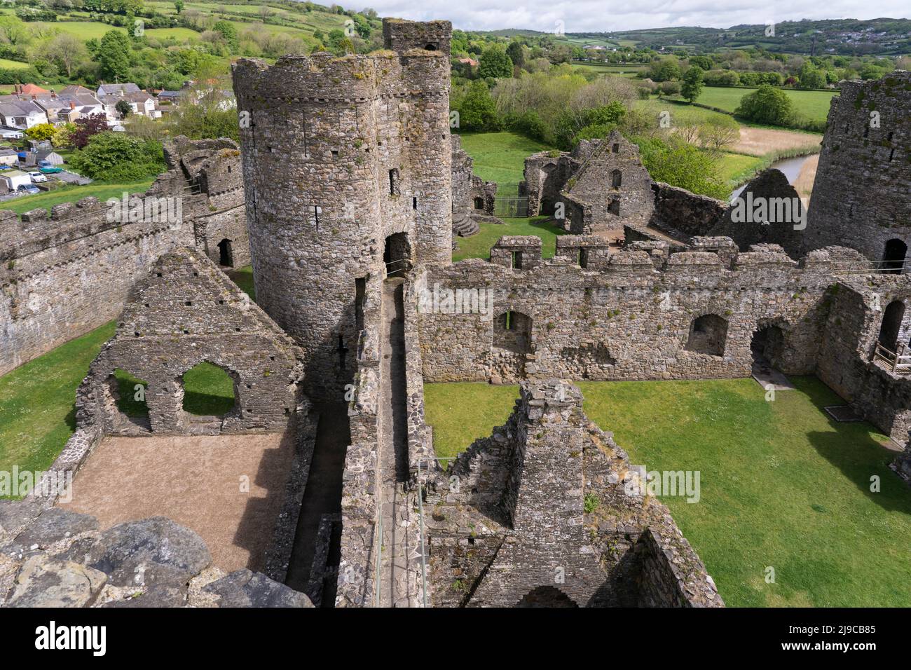 Eine Luftaufnahme von Kidwelly Castle, mit Blick auf die späteren Hall, Keep, Inner ward, Keep und Outer Walls an einem Frühlingstag im Mai. Carmarthen, Wales, Großbritannien Stockfoto