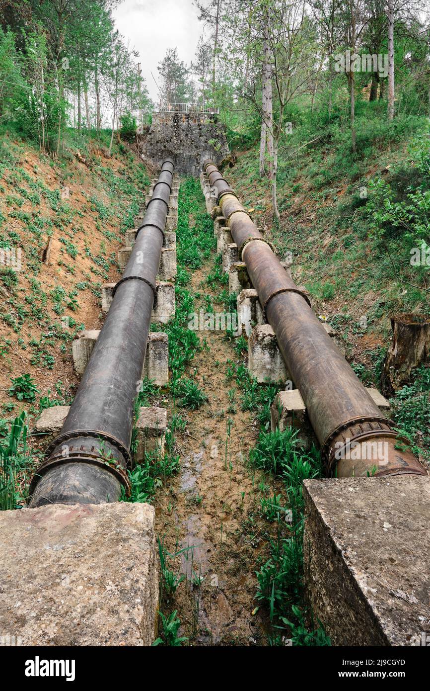 Große Metallrohre, niedrige Winkelansicht der Wasserleitungen an der Wasserkraftzentrale Stockfoto