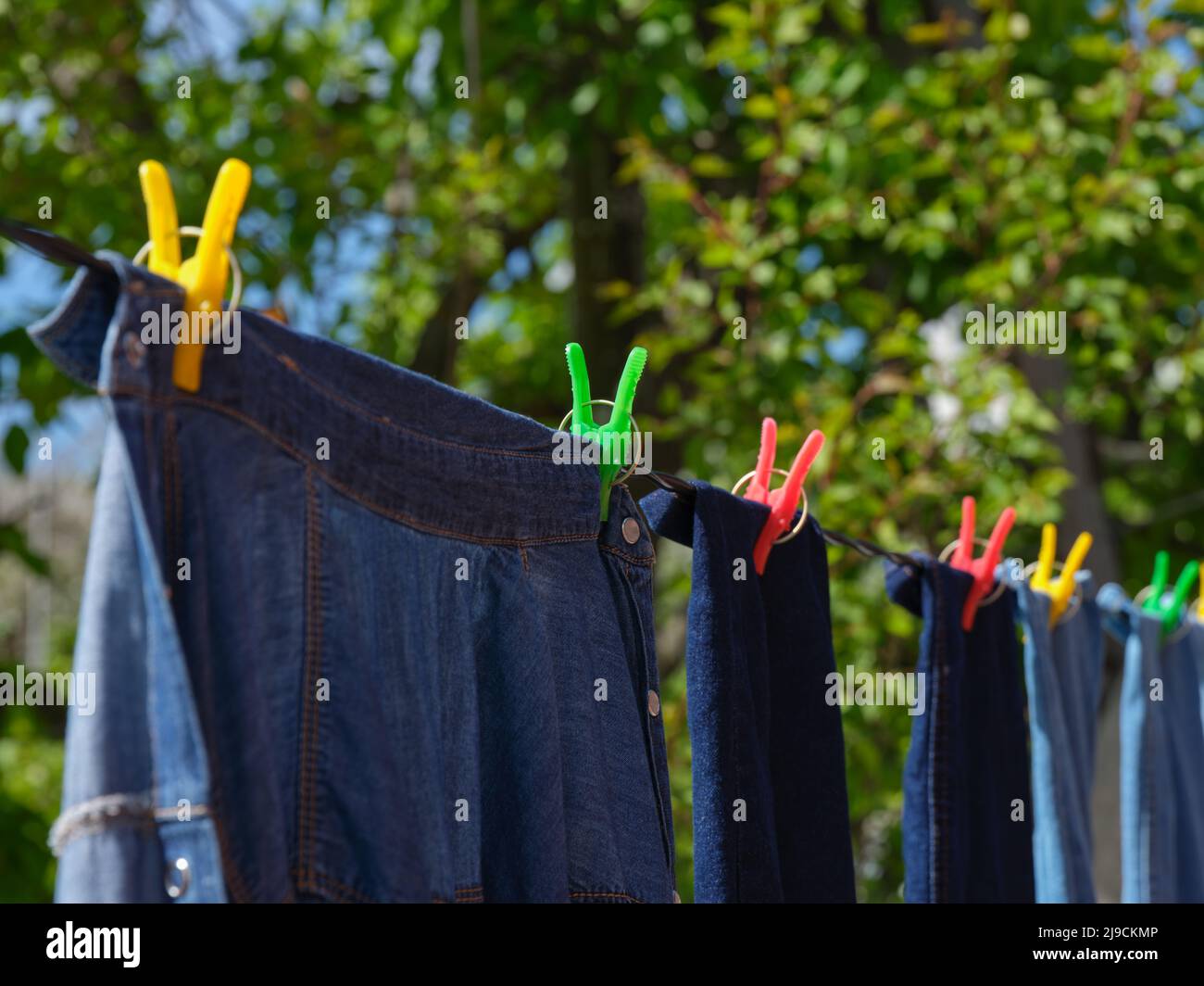 Denim-Kleidung, die an einer Wäscheleine hängt. Nahaufnahme. Stockfoto
