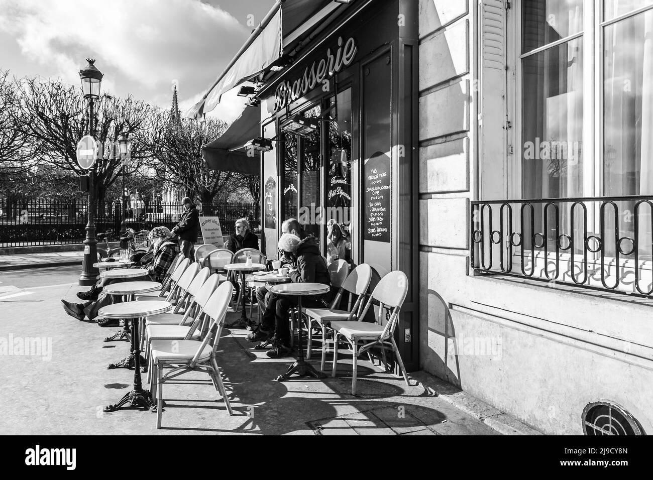 Paris, Frankreich - 20. Februar 2010: Pariser und Touristen sitzen in einem Café im Freien in Paris. Stockfoto