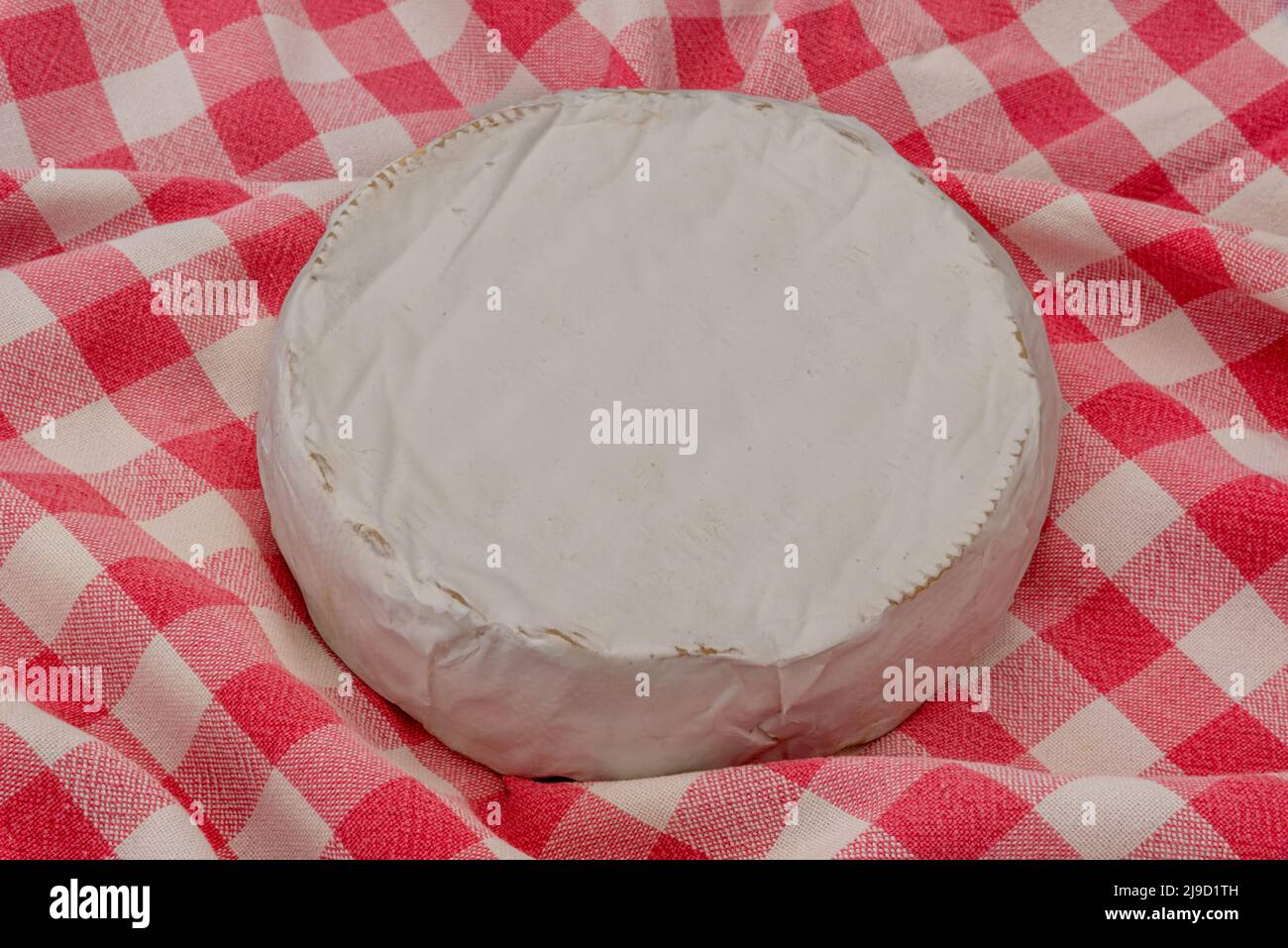 Brie-Frischkäse-Rad auf einer rot karierten Tischdecke Stockfoto