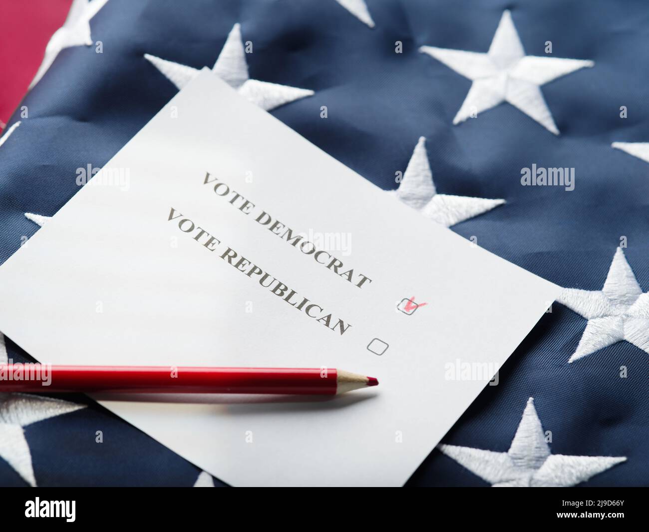 Vor dem Hintergrund der amerikanischen Staatsflagge steht ein Stimmzettel und ein Bleistift. Eine Inschrift, die dazu aufruft, für einen Demokraten und einen Republikaner zu stimmen. Mark Stockfoto