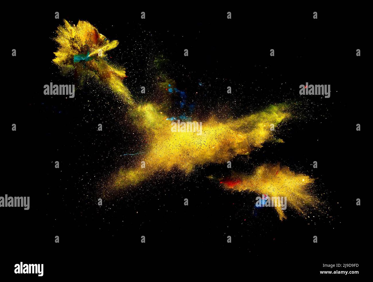 Bizarre Formen von goldenem Glitter und Farbpuderfarbe explodieren vor einem schwarzen Hintergrund, um fantastische Farben und Formen zu geben. Stockfoto