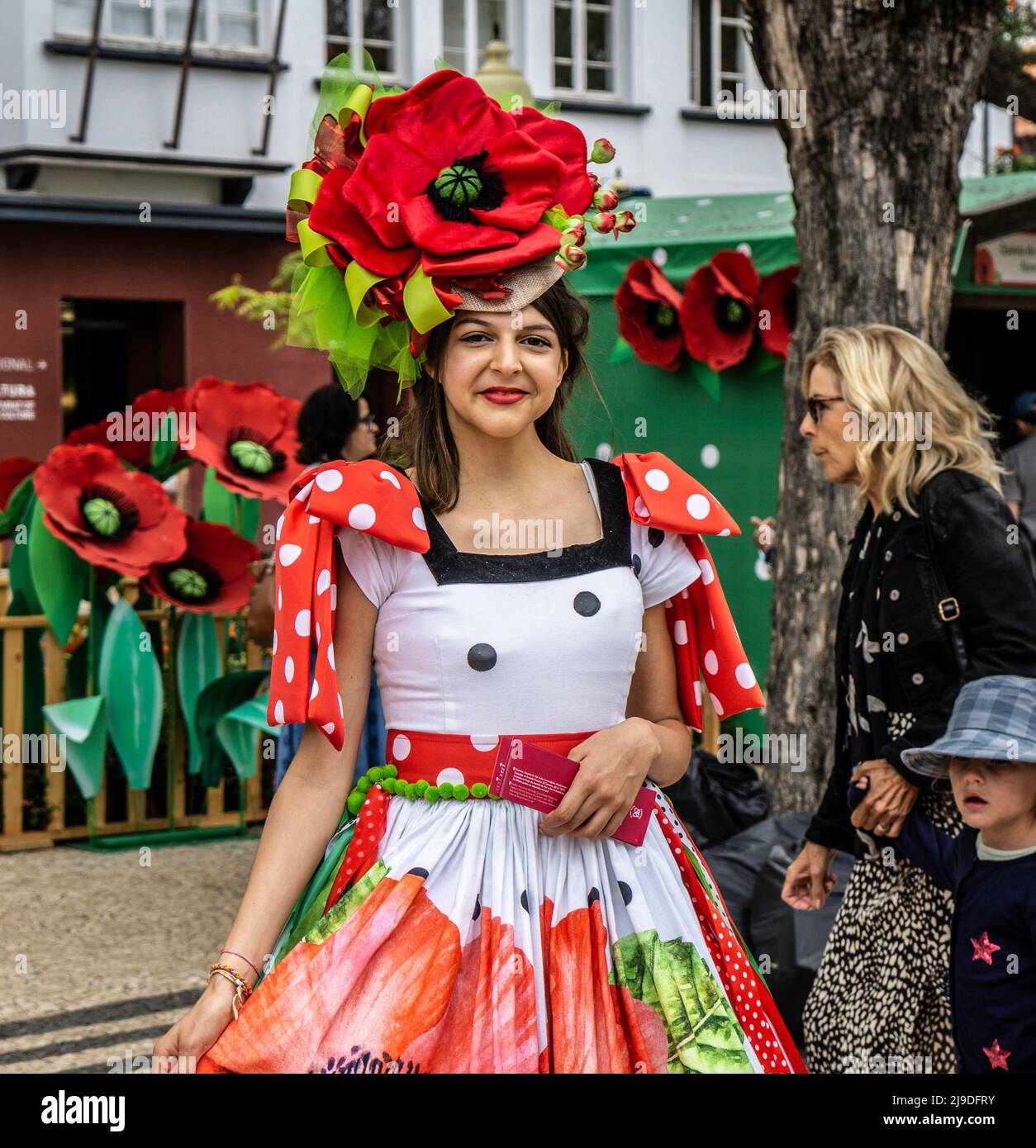 Eine junge Frau in traditioneller Kleidung, die das Blumenfest in Funchal, Madeira, fördert. Stockfoto