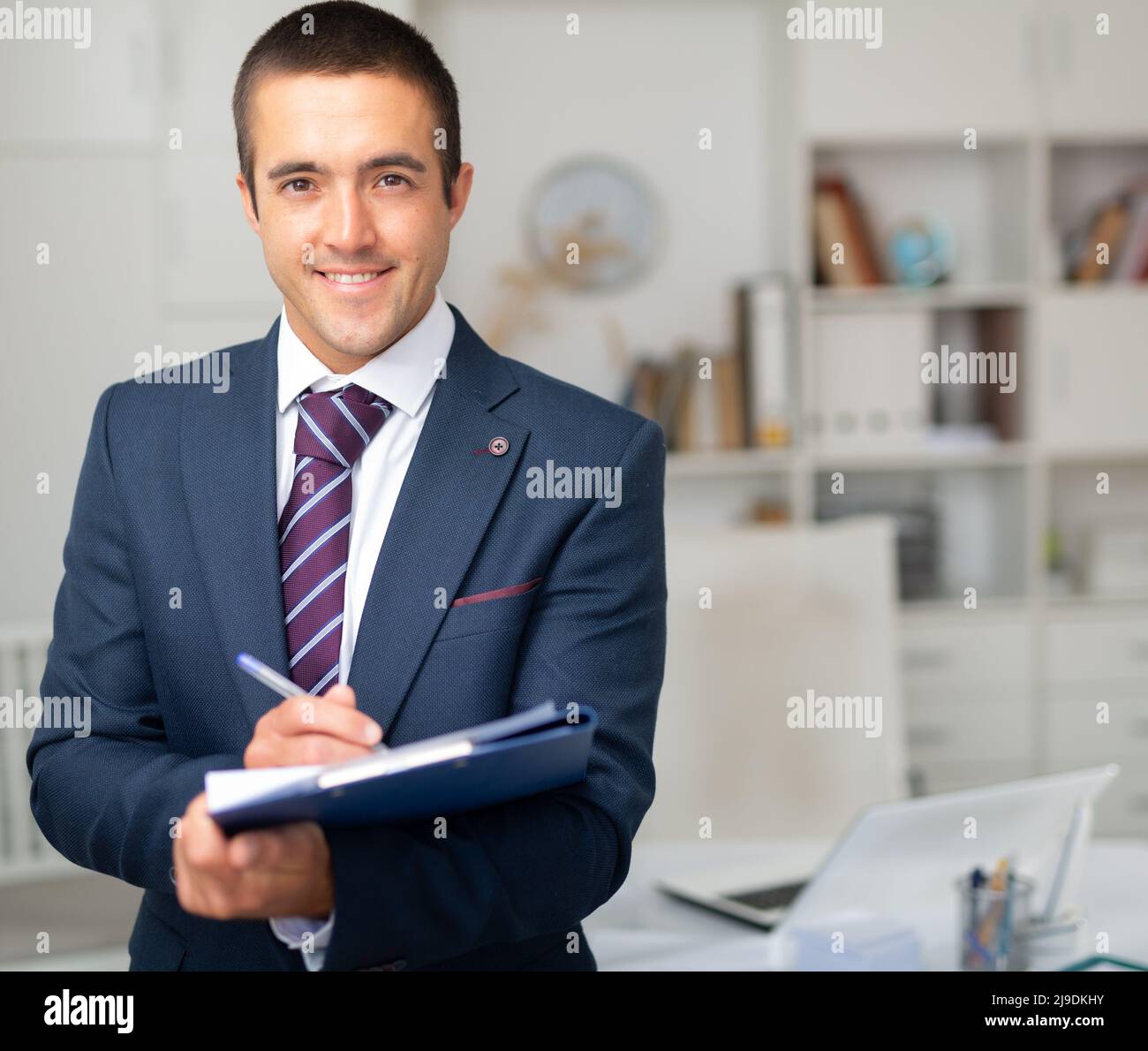 Porträt eines positiven Geschäftsmanns mit Dokumentenmappe Stockfoto