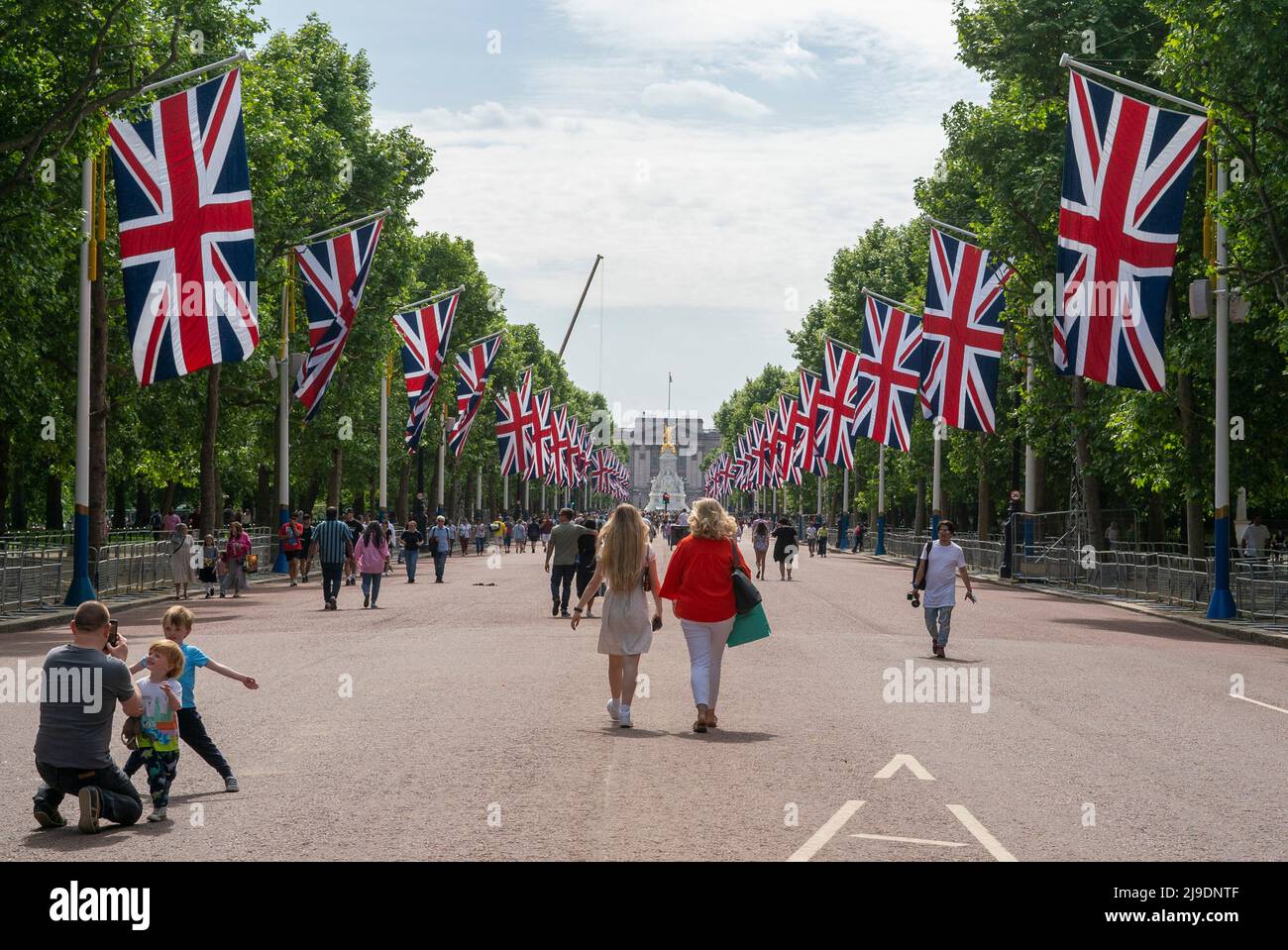 Tourist fotografiert die Union Jack-Flaggen, die von der Mall bis zum Buckingham Palace vor dem Platinum Jubilee der Königin gehangen wurden Stockfoto