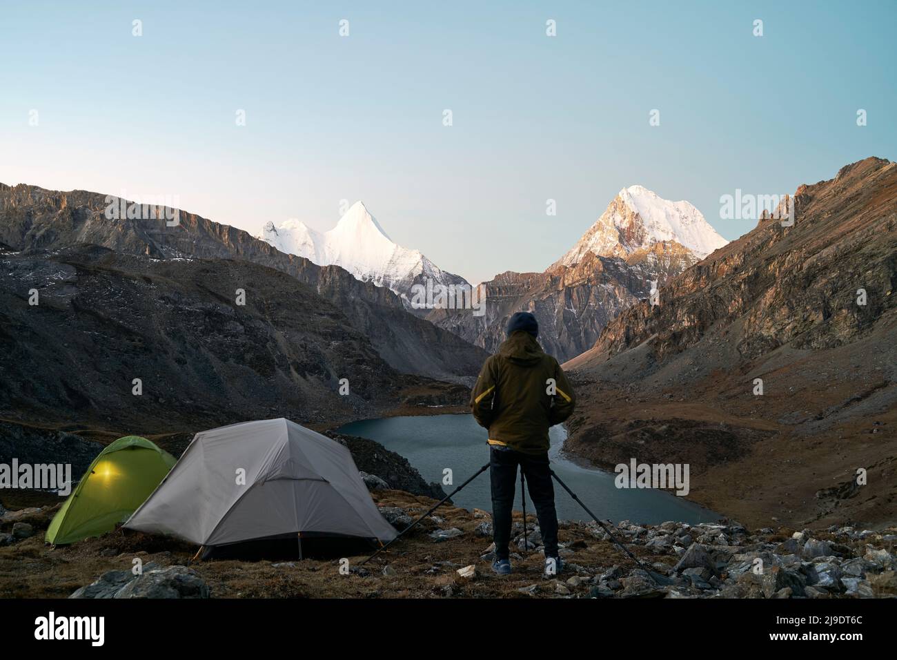 asiatischer Camper-Fotograf, der ein Bild von Berg und See im yading-Nationalpark, Bezirk daocheng, Provinz sichuan, china, macht Stockfoto