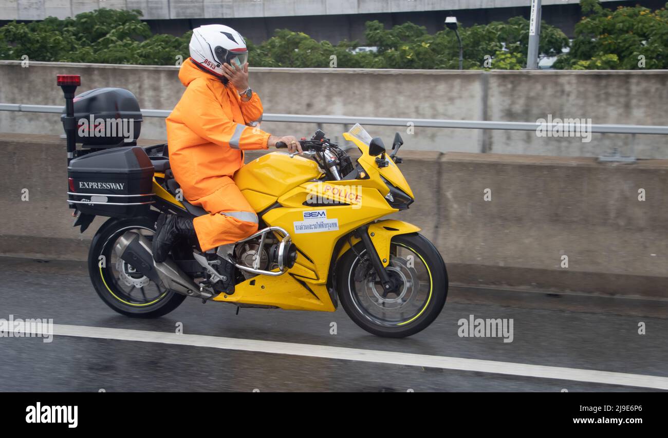 BANGKOK, THAILAND, MAI 11 2022, Ein Polizist in einem wasserdichten Anzug fährt ein Sportmotorrad Stockfoto