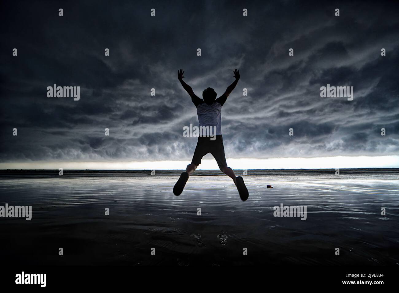 Ein Mann springt, während er für Fotos am Meer von Udaipur Beach, Digha (ca. 200 km von Kalkutta) mit einer dramatischen Wolkenlandschaft posiert. Das India Meteorological Department (IMD) hat vorhergesagt, dass der Monsunregen aufgrund der Auswirkungen der zwei Zyklone Asani und Karim voraussichtlich eine Woche zu Beginn dieses Jahres eintreffen wird. (Foto von Avishek das / SOPA Images/Sipa USA) Stockfoto