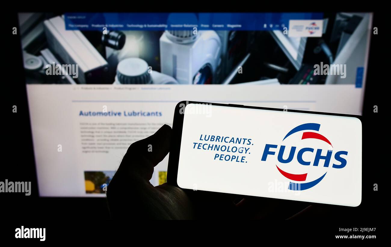 Person, die das Smartphone mit dem Logo des deutschen Schmierstoffunternehmens Fuchs Petrolub SE auf dem Bildschirm vor der Website hält. Konzentrieren Sie sich auf die Telefonanzeige. Stockfoto