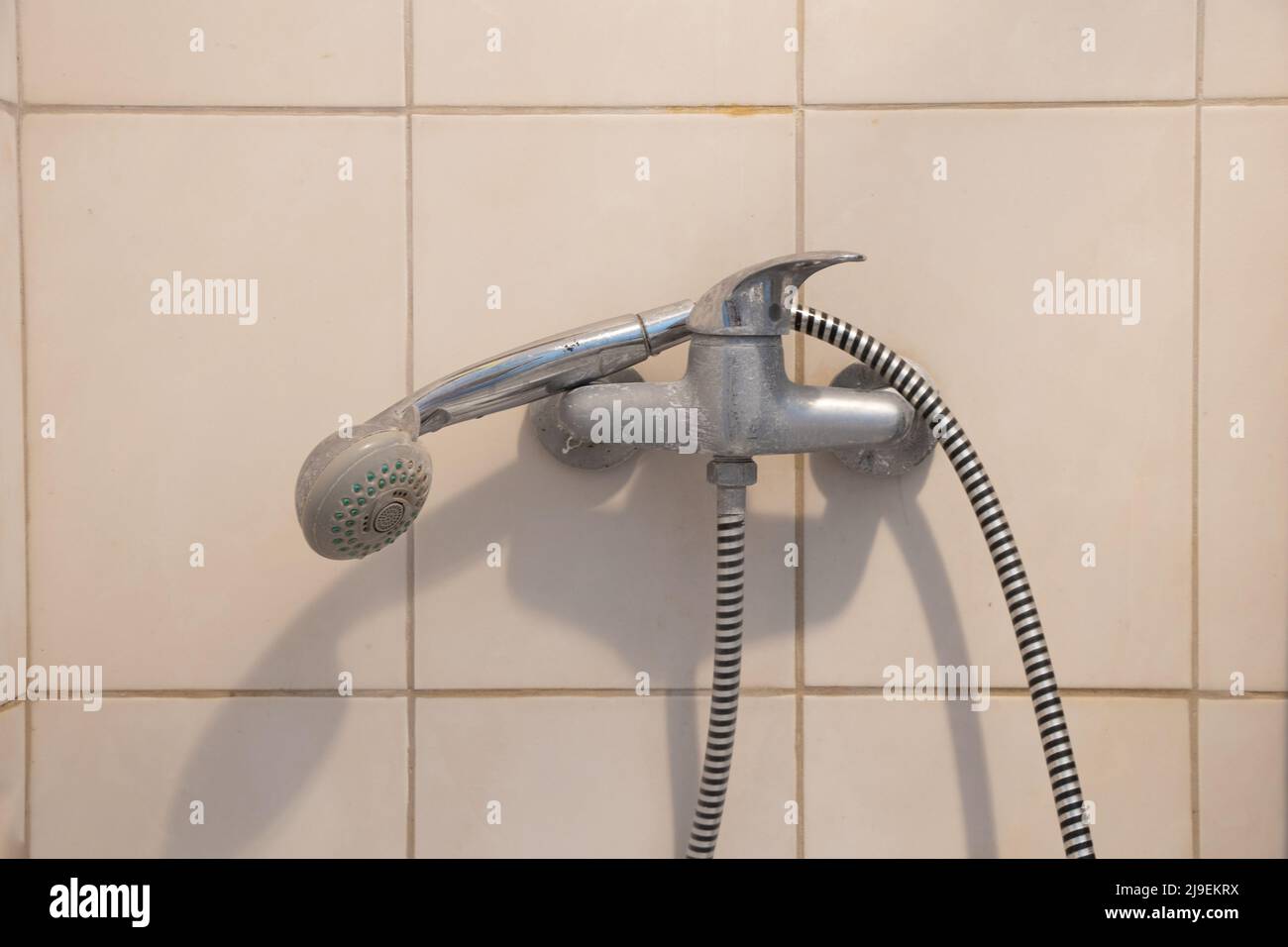 Duschhahn mit einem Wasserkopf auf einem langen Schlauch im Badezimmer, Duschkabine mit einem Wasserhahn Stockfoto