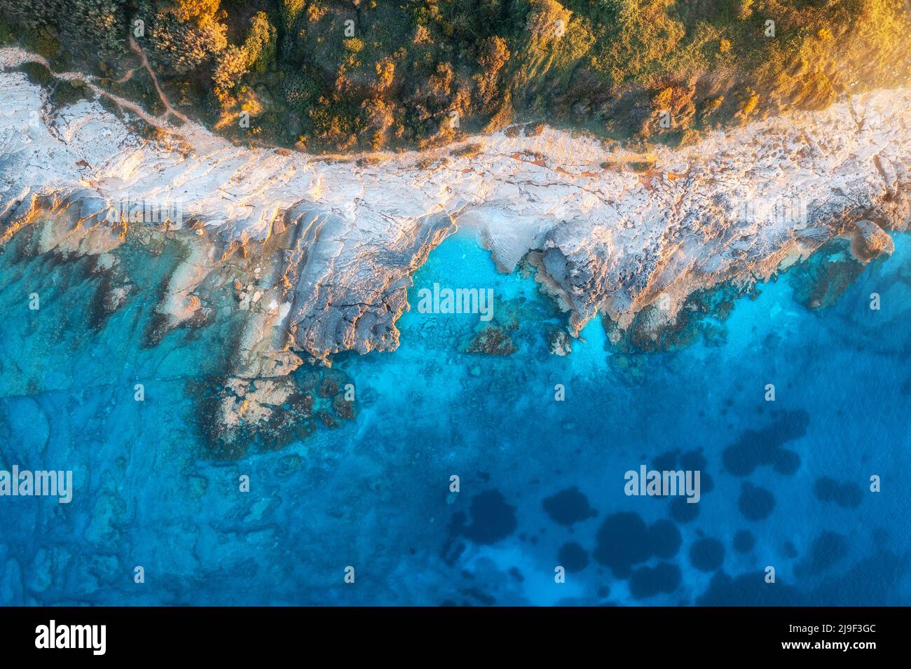 Luftaufnahme des blauen Meeres, Felsen im klaren Wasser, Strand, grüne Bäume Stockfoto