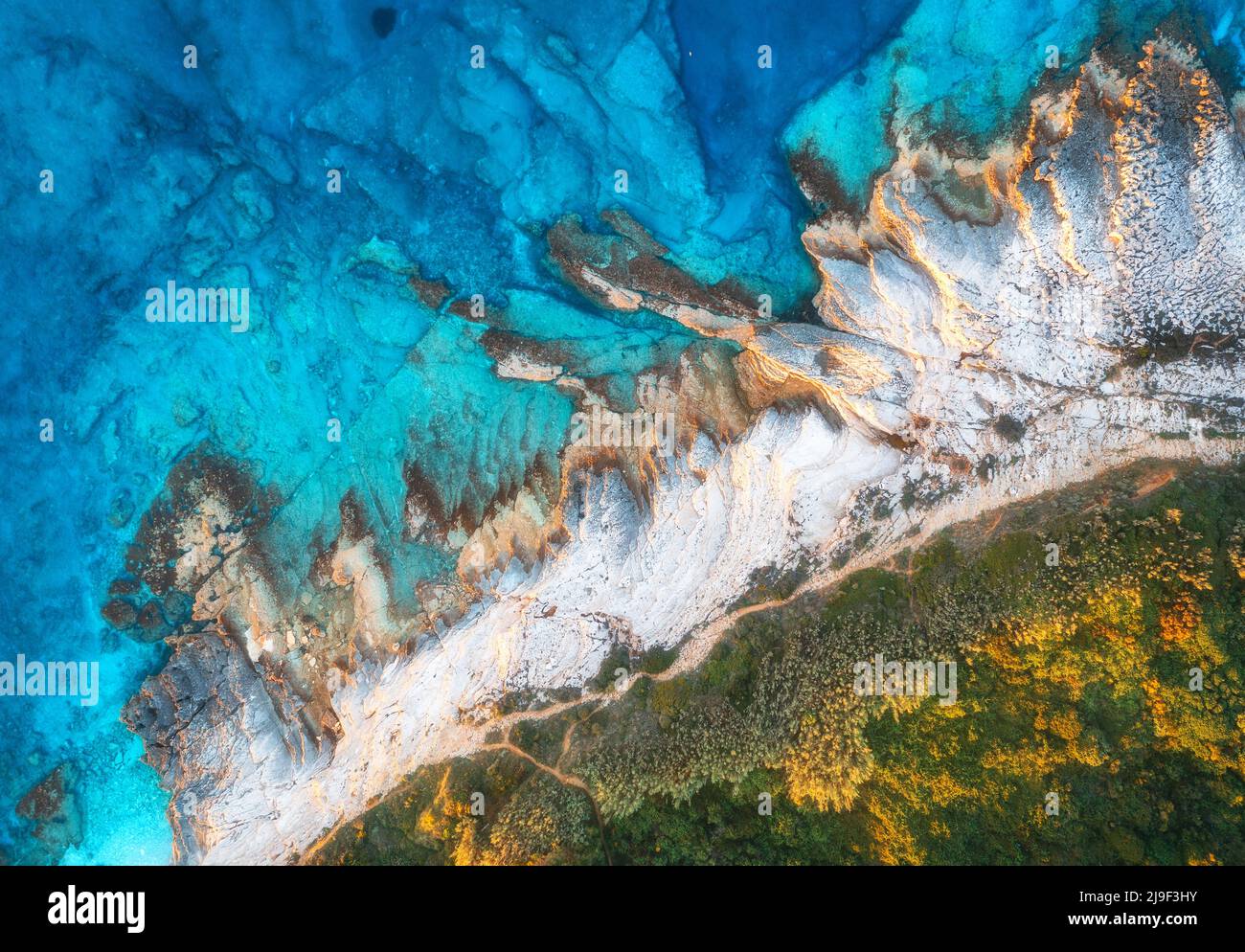 Luftaufnahme des blauen Meeres, Felsen im klaren Wasser, Strand, grüne Bäume Stockfoto
