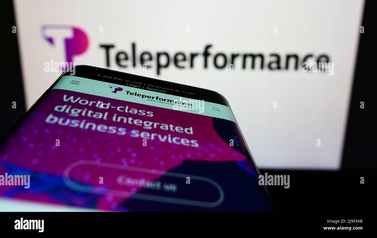 Smartphone mit Website des französischen Callcenter-Unternehmens TeleprePerformance SE auf dem Bildschirm vor dem Unternehmenslogo. Konzentrieren Sie sich auf die obere linke Seite des Telefondisplays. Stockfoto
