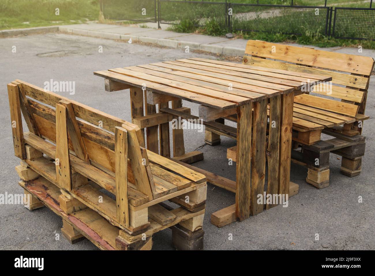 Palette Gartenmöbel. Rustikaler Holztisch und Bänke mit Paletten Stockfoto