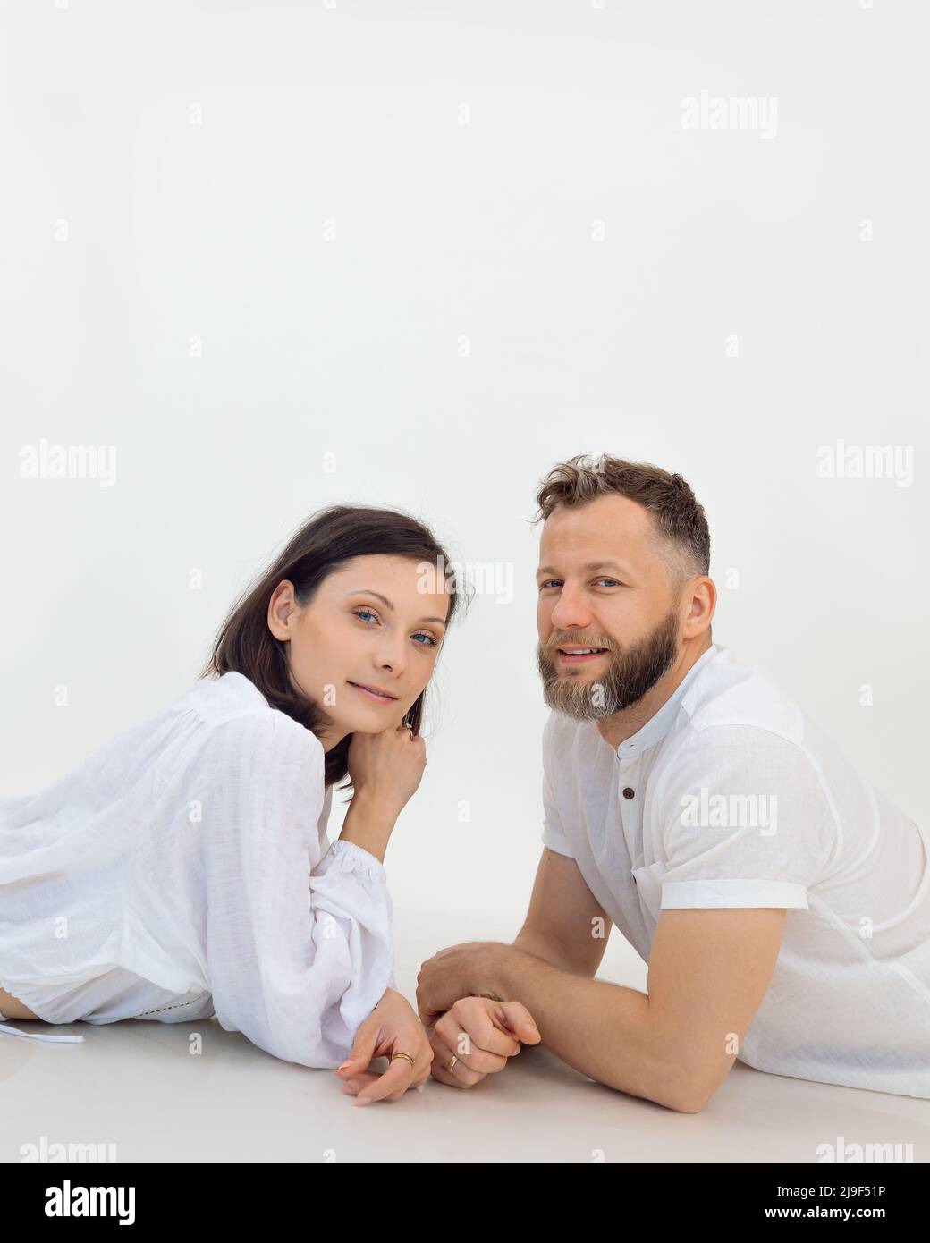 Vertikale Studioaufnahme von Mann und Frau, die auf dem Boden liegend auf die Kamera schauen. Körper und Gesundheit, Fitness und Physiotherapie Stockfoto