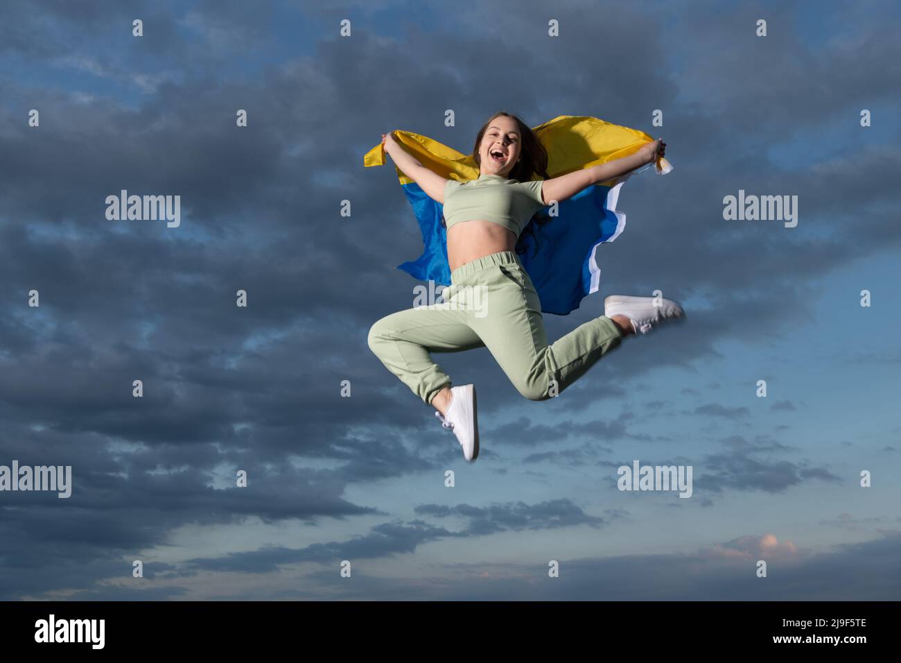 Happy teen Mädchen springen mit nationalen ukrainischen Flagge der ukraine, Glück und Freiheit Stockfoto