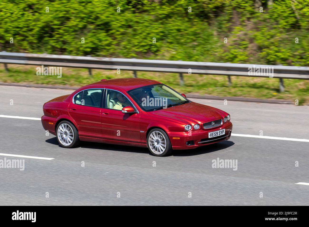 2010 Red British Jaguar X-TYPE SE 2198cc Diesel 6-Gang Sequential 4dr Limousine; Fahren auf der M61 Motorway, Manchester, Großbritannien Stockfoto