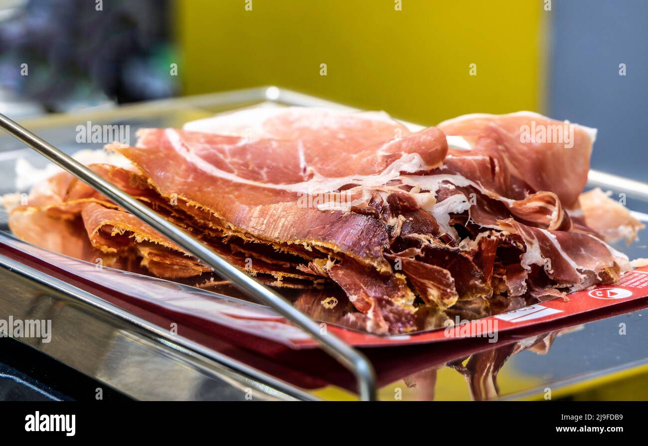 Iberischer Schinken, der mit Mais gefüttert wird, auf einer Waage. Trocken ausgehärtete Schinkenscheiben. Jamon iberico de bellota Stockfoto