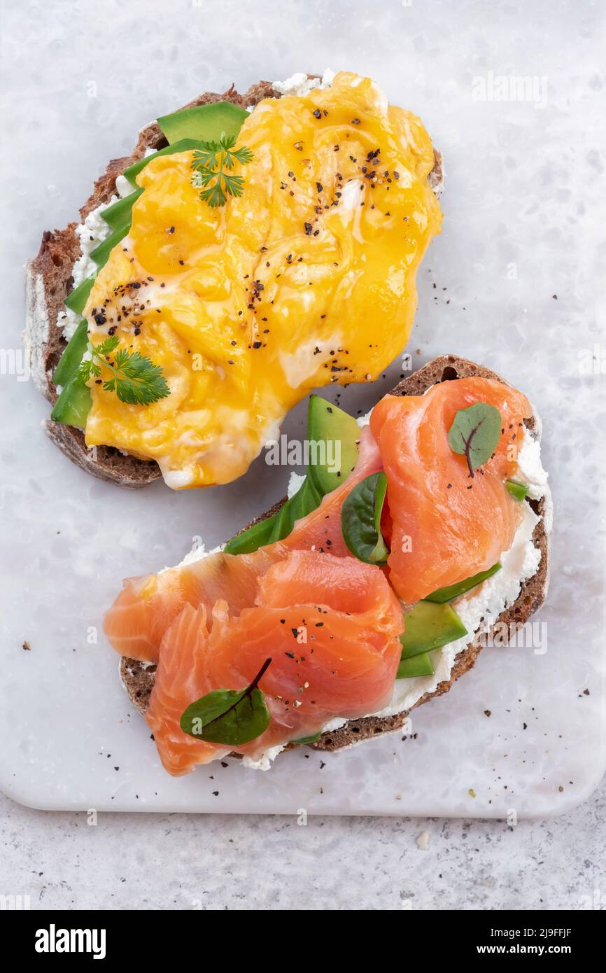 Rührei mit geräuchertem Lachs, Frischkäse und Avocado auf Toast Stockfoto
